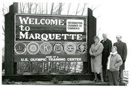 Four People Standing Next to Welcome to Marquette Sign (Part of the NMU Historic Photographs Collection)