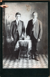 Two Men With Photographs on Table