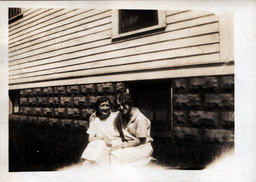 Two Women in Front of House