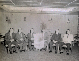 Blue Key Fraternity Installation and Initiation 1961, 1962: Six Men Sitting Posed With Banner