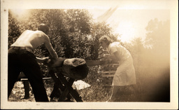 Two People Sawing Log