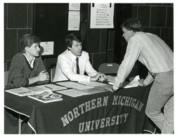 Student Talking to Man behind General Assistance Table (Part of the NMU Historic Photographs Collection)