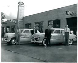 Marquette High School and Baraga High School Training Cars in front of Olson Ford Dealership (Part of the NMU Historic Photographs Collection)