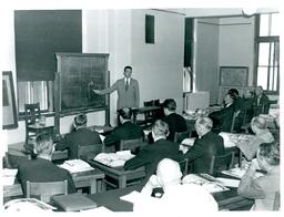 Driving Instructor Giving Lecture to Class of Adult Men Instructor Teaching Students about Engine (Part of the NMU Historic Photographs Collection)