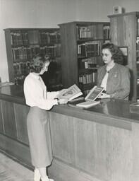 Woman Checking out Driving Manuals at Original Olson Library (Part of the NMU Historic Photographs Collection)