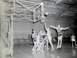 NMC Alumni Basketball 1960-61: Men Playing Basketball by Net