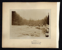 Men on Logs near Rapids