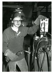 Student Wearing Welding Gear and Standing next to Welding Machine (Part of the NMU Historic Photographs Collection)