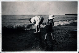 Man and Child Looking for Beach Rocks