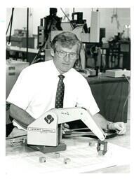 Man Sitting behind Robotic Arm (Part of the NMU Historic Photographs Collection)