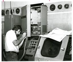 Man Working on Door of Electronics Box (Part of the NMU Historic Photographs Collection)